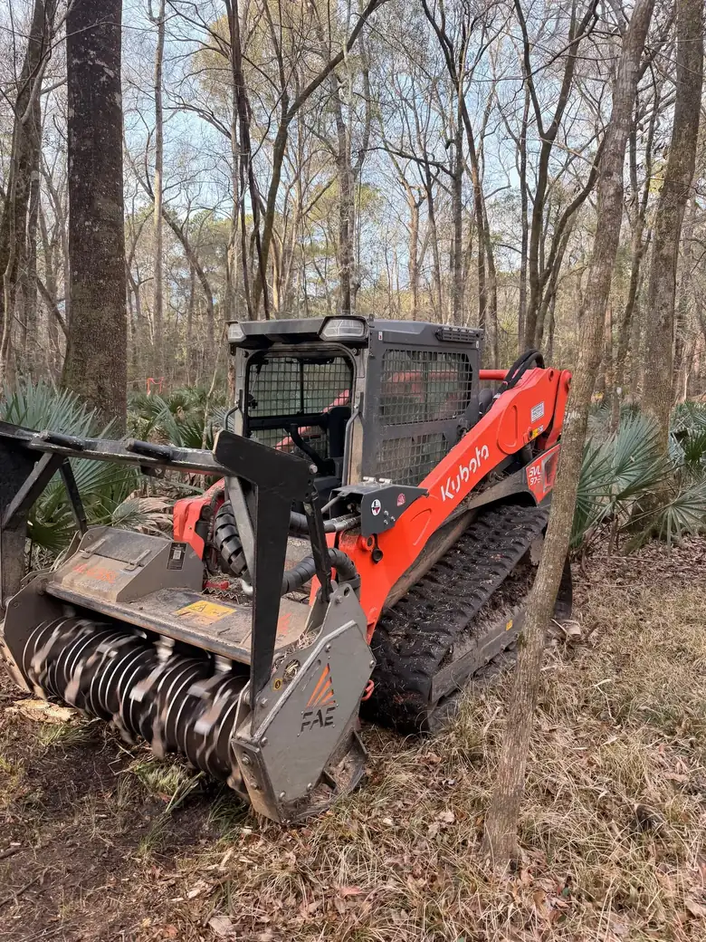 Orange tracked mulcher in a Lowcountry pine lot