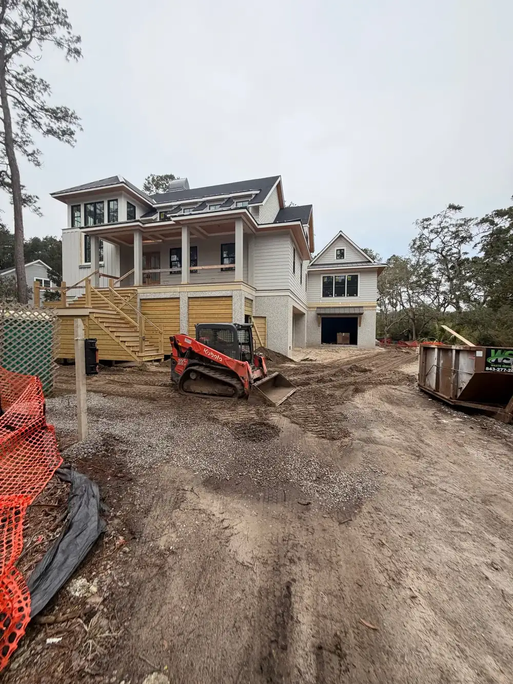 Track loader working a back yard beside a house