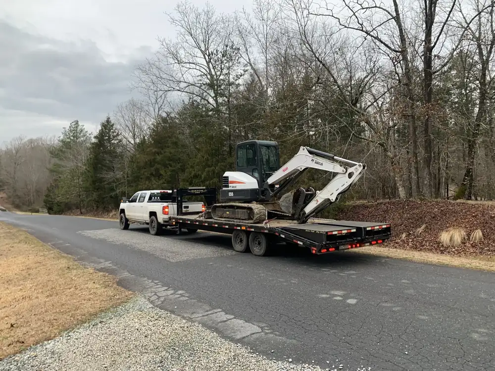 Pickup towing an excavator on a trailer